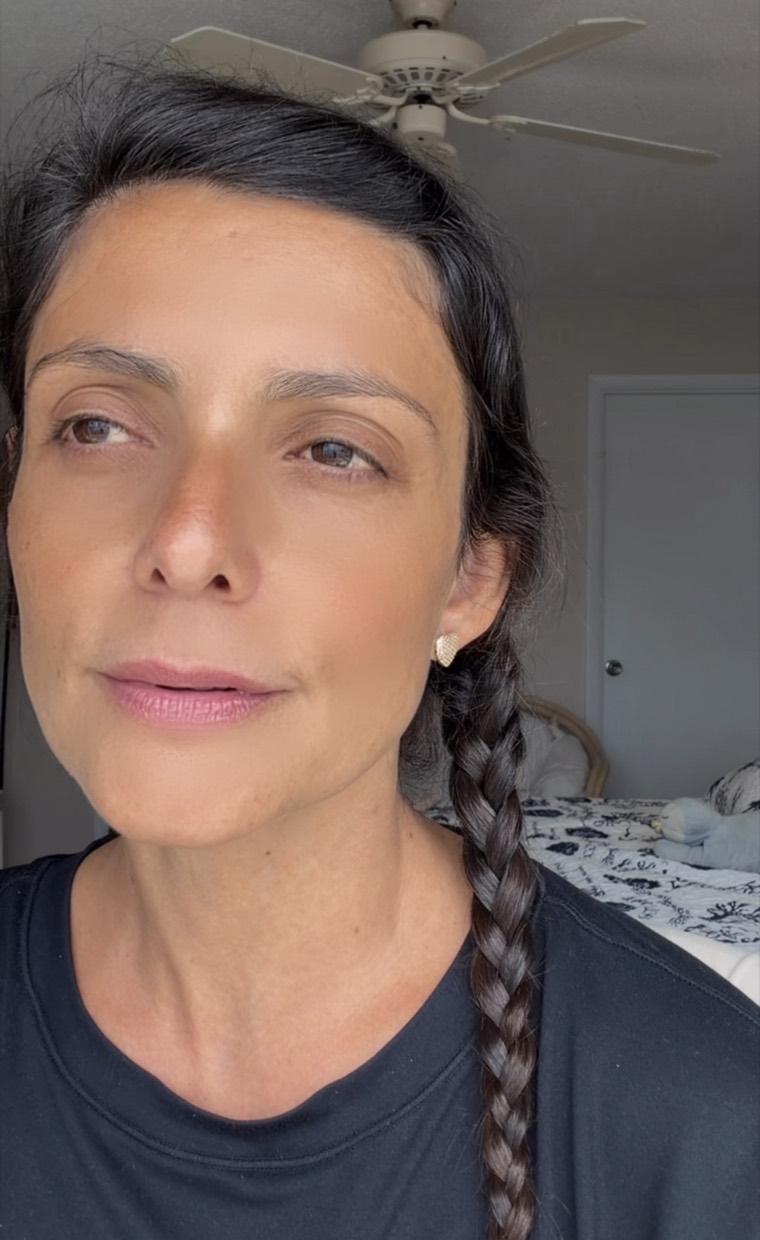 Drica Ricci em retrato próximo, cabelo trançado, sem maquiagem, olhando para a câmera.